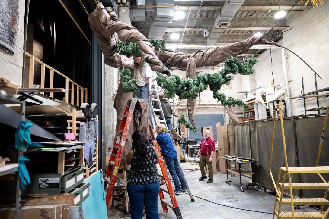 Students construct a giant tree back stage.